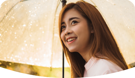 Smilling young woman holding an umbrella on a rainy day